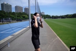 Yoshimi Yamashita of Japan, takes off her protective mask during a training session, June 27, 2022, at JFA YUME Field in Chiba, near Tokyo.