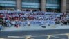 Sejumlah peserta aksi demo membentangkan spanduk dan meneriakan yel-yel dalam aksi protes di depan sebuah kantor cabang Bank Sentral China di Zhengzhou, Henan, pada 10 Juli 2022. (Foto: AP via Yang) 