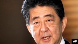 FILE - Japan's outgoing Prime Minister Shinzo Abe speaks to the media as he arrives at the prime minister's office for a Cabinet meeting in Tokyo on Sept. 16, 2020.