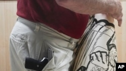 John Deloca, owner of Seneca Sporting Range, pockets his 9mm semiautomatic handgun as he prepares a shooting demonstration at his gun range, June 23, 2022, in New York.