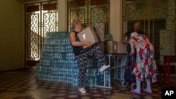 An elderly woman receives humanitarian food aid from the Kramatorsk city council, eastern Ukraine, July 7, 2022.