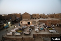 Men sleep on charpoy rope beds, early in the morning during a heatwave, on a roof in Jacobabad, Pakistan, May 15, 2022. (REUTERS/Akhtar Soomro)