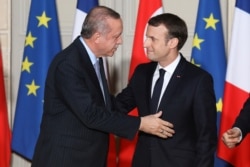 FILE - French President Emmanuel Macron greets Turkish President Recep Tayyip Erdogan during a joint news conference at the Elysee Palace in Paris, France, Jan. 5, 2018.