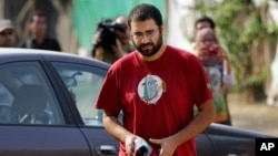 Egypt’s most prominent activist Alaa Abdel-Fattah arrives outside a court that convicted 23 activists of staging an illegal demonstration and sentenced them each to three years in jail, in Cairo, Egypt, Oct. 26, 2014. 