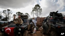 FILE - A Turkish soldier is seen atop the Bursayah hill in Syria's Afrin district, March 3, 2018. Since Turkey took control of Afrin, rights groups and Kurdish activists have accused Turkey and its allies of settling Arab and Turkmen families in the predominately Kurdish region. 
