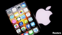 FILE - An Apple iPhone is pictured next to the logo of Apple in Bordeaux, southwestern France, Feb. 26, 2016. 