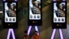 Children use smartphones near monitors displaying a Chinese action movie "Wolf Warrior 2" at a cinema in Beijing, Aug. 10, 2017.