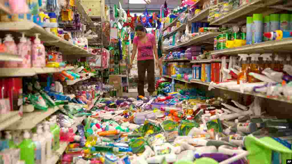 Nina Quidit cleans up the Dollar Plus and Party Supplies Store in American Canyon, California, after an earthquake, Aug. 24, 2014.