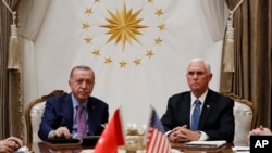 Vice President Mike Pence, left, and Secretary of State Mike Pompeo, walk to a car to drive to a meeting with Turkish President Recep Tayyip Erdogan, in Ankara, Turkey, Oct. 17, 2019. 