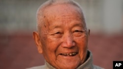FILE - Nepalese mountain climber Min Bahadur Sherchan, 85, smiles as he finishes his morning yoga workout at his residence in Kathmandu, Nepal, April 12, 2017. Officials said Sherchan died May 6. 