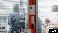 Para petugas medis merawat seorang pasien di unit perawatan intensif virus corona di Rumah Sakit Brescia Poliambulanza, Lombardy, Italia, 17 Maret 2020. (Foto: AFP)