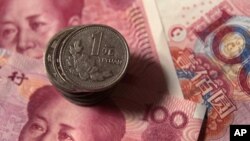 Chinese one-yuan coins placed on 100-yuan banknotes, Dec. 30, 2010 (file photo).