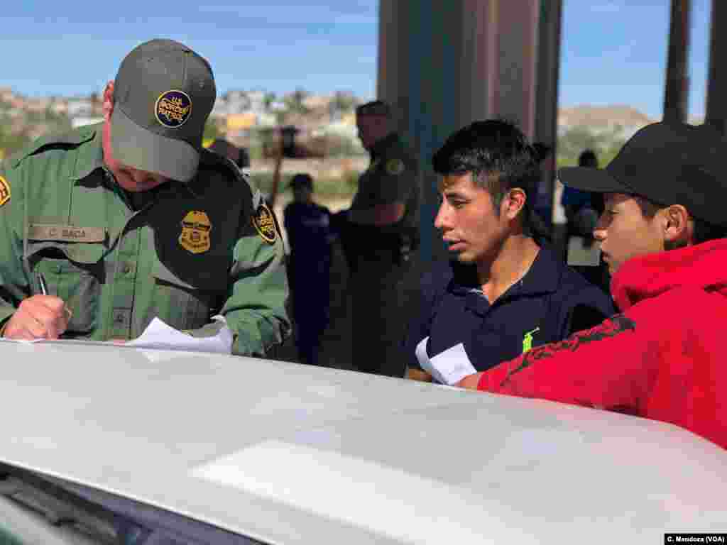 Agent C. Baca processes a group of Guatemalan migrants who turned themselves in to authorities after crossing the U.S.-Mexico border without authorization, at the border between Ciudad Juarez, Mexico, and El Paso, Texas, April 9, 2019. 