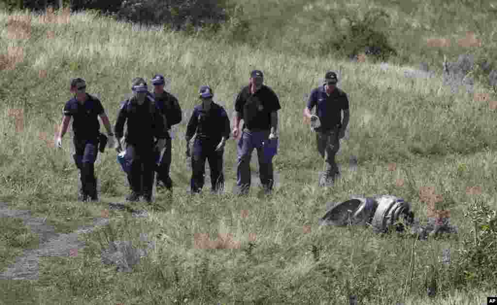 Australian experts examine the area of the Malaysia Airlines plane crash in the village of Hrabove, Donetsk region, eastern Ukraine, Aug. 1, 2014. 