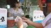 A man counts a stack of Cambodian riels in front of a currency exchange counter in Phnom Penh, Cambodia, on April 7, 2016. (Leng Len/VOA Khmer)