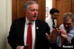 FILE - U.S. Representative Mark Meadows (R-NC) and Representative Jim Jordan (R-OH) (R), leaders in the House Freedom Caucus, talk to reporters as they walk between meetings at the U.S. Capitol in Washington, Jan. 18, 2018.