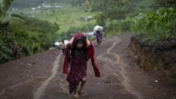 A child carries supplies up a muddy mountainside in Nuevo Queja, Guatemala, Thursday, July 8, 2021. (AP Photo/Rodrigo Abd)