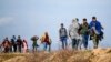 Des migrants marchent sur une route près du poste frontière d'Ipsala à Edirne, à la frontière turco-grecque, le 3 mars 2020.