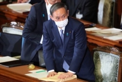 Japanese Prime Minister Yoshihide Suga attends to deliver his policy speech at the upper house of parliament in Tokyo, Oct. 26, 2020.
