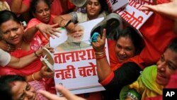 FILE - Activists of India’s opposition Congress party beat a placard with portrait of Prime Minster Narendra Modi during a protest in Mumbai, India, Aug. 5, 2015. 