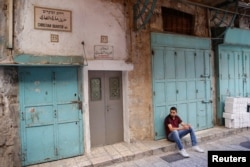 A sign in multiple languages reflects the Christian Quarter's cultural mix. A recent wave of violence has made minority Christians uneasy.