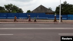 Une femme congolaise court près de la RTNC, Kinshasa, 30 décembre 2013.