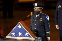 FILE - Acting U.S. Capitol Police Chief Yogananda Pittman pays respects to U.S. Capitol Police officer Brian Sicknick in the Capitol Rotunda in Washington, Feb. 2, 2021.