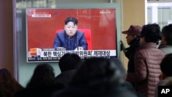 FILE - People at Seoul Railway Station in Seoul, South Korea, watch a TV news program showing North Korean leader Kim Jong Un, March 3, 2016.