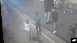 This image provided by Star TV, Feb. 15, 2017, of closed circuit television footage from Monday, Feb 13, 2017, shows a woman (left) at Kuala Lumpur International Airport in Sepang, Malaysia, who police say was arrested in connection with the death of Kim Jong Nam, the half brother of North Korean leader Kim Jong Un. (Star TV via AP)