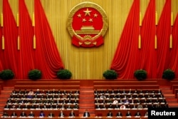 China's President Xi Jinping and other delegates listen as China's Premier Li Keqiang (not pictured) delivers a government work report during the opening session of the National People's Congress (NPC) at the Great Hall of the People in Beijing, China.