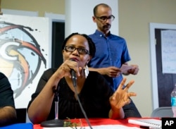 Haitian-American writer Edwidge Danticat speaks as Dominican-American writer Junot Diaz, stands by during a gathering of about 150 activists and community members in Miami, June 24, 2015.