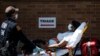FILE - A medical worker transports a patient outside a special COVID-19 area at Maimonides Medical Center, in the Brooklyn borough of New York City, May 17, 2020.