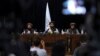 FILE - In front of a Taliban flag, then-Taliban spokesman Zabihullah Mujahid, center, speaks at his first news conference, in Kabul, Afghanistan, Aug. 17, 2021. 
