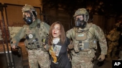 FILE - A bloodied demonstrator is arrested by federal police during a Black Lives Matter protest at the Mark O. Hatfield United States Courthouse, July 27, 2020, in Portland, Oregon.