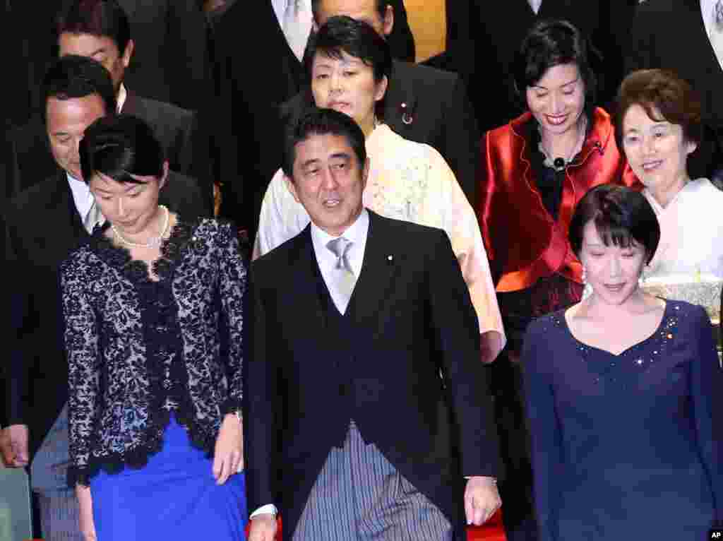 Japan&#39;s Prime Minister Shinzo Abe, front row center, and his new Cabinet members, including five women, head for a group photo session following the first Cabinet meeting at the prime minister&#39;s official residence in Tokyo.