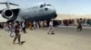 Stotine ljudi trči duž piste pored američkog vojnog transportnog aviona C-17, dok se on kreće pistom u Kabulu, Afganistan, 16. avgusta 2021.