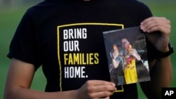 Harrison Li holds a photo of his father, Kai Li, on Jan. 23, 2024, in Palo Alto, Calif. Li's father, Kai, remains detained in China on espionage charges his family says are bogus and