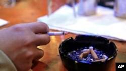 Dale Sanders fume une cigarette au Restaurant & Bar à Durham, Caroline du Nord, jeudi 17 décembre 2009 photo, (AP Photo / Gerry Broome).