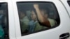 Ny Chakrya, center, former ADHOC and a National Election Committee member who worked at the organization, sits in a car and is transported back to an Anti-Corruption Unit, ACU, after a short appearance at Phnom Penh Municipal Court, in Phnom Penh, Cambodia, Saturday, April 30, 2016. Cambodian authorities arrested five human rights workers last Friday on accusations they tried to help cover up a woman's affair with the deputy leader of the opposition Cambodia National Rescue Party. The action is the latest in a series by Prime Minister Hun Sen's government putting legal pressure on its critics and political opponents. (AP Photo/Heng Sinith)