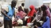 ARCHIVES - Des femmes et des enfants du sud de la Somalie font la queue pour recevoir des aliments cuits distribués par le Programme alimentaire mondial (PAM) à Mogadiscio, en Somalie, le 20 août 2011.