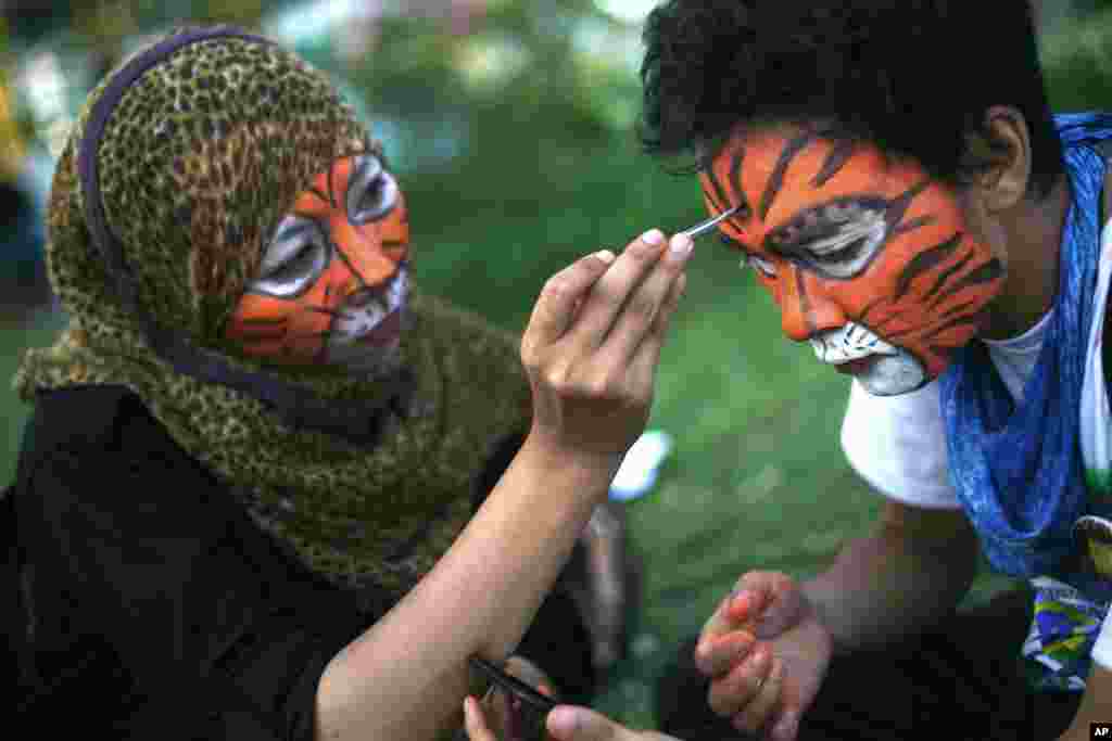 Students paint their faces during a rally calling for Sumatran tiger conservation ahead of the Global Tiger Day in Medan, North Sumatra, Indonesia. The Sumatran tiger is the world's most critically endangered tiger subspecies with only fewer than 400 remain in the wild and may become extinct in the next decade due to poaching and habitat loss.