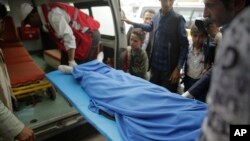 Yemenis carry the body of a girl who was killed in an explosion, at a hospital in Sanaa, Yemen, April 7, 2019. 