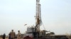Workers are seen at an oil exploration site in Bulisa district approximately 244km (152 miles) North-West of Kampala, January 20, 2012. 