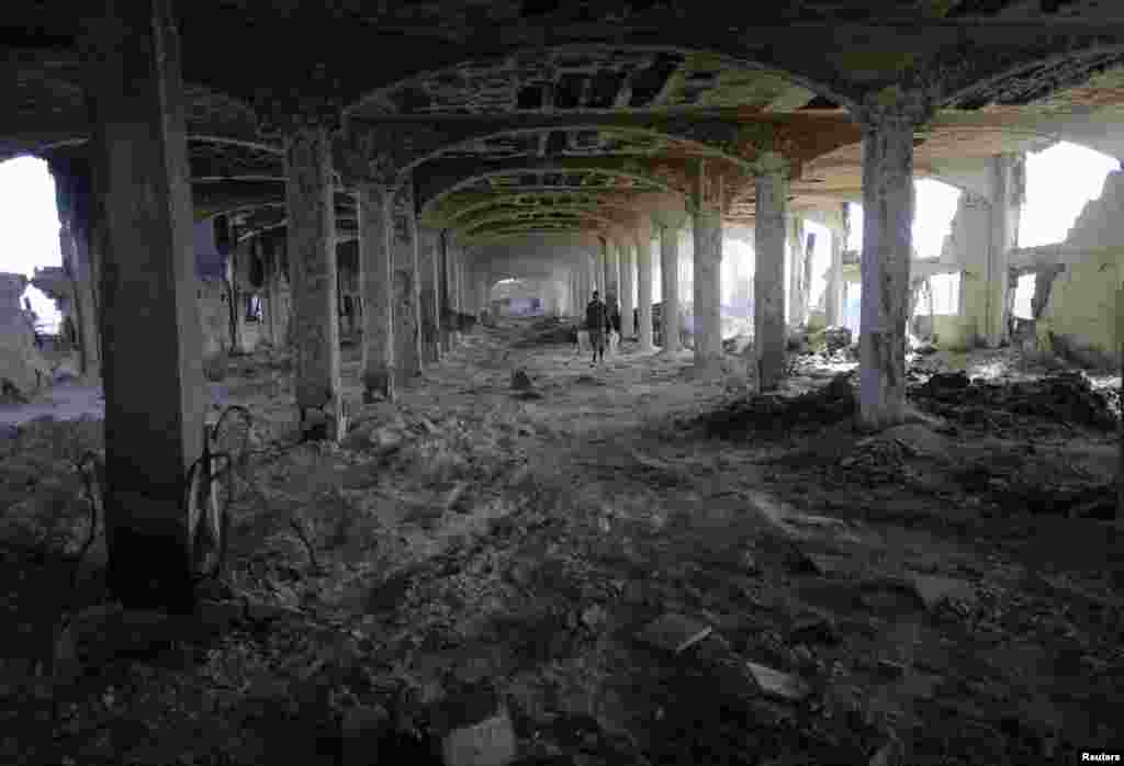 A Palestinian worker walks inside al-Awdah food factory in Deirl al-Balah in the central Gaza Strip, Aug. 14, 2014.
