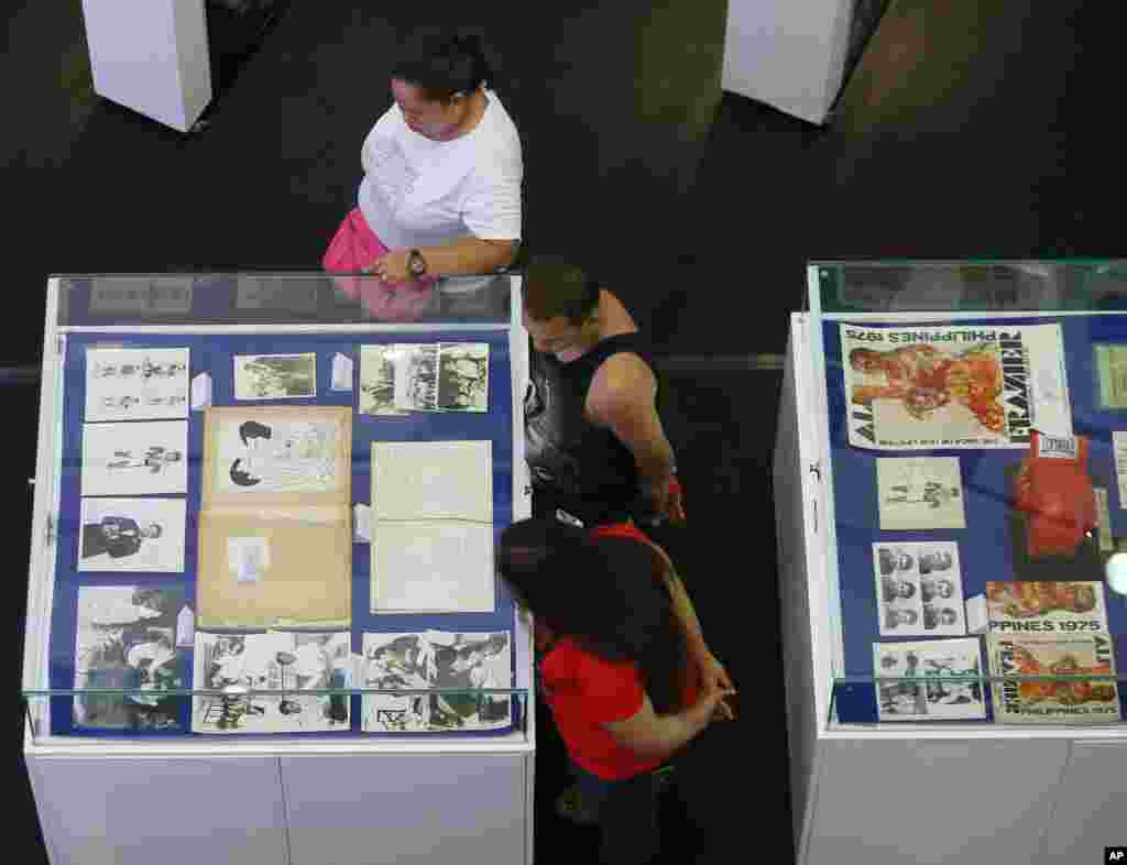 Filipino fans look at memorabilia from the "Thrilla in Manila" World Heavyweight boxing fight between Muhammad Ali and Joe Frazier in the suburban Quezon city, northeast of Manila, Philippines, June 10, 2016.
