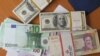 The euro and United States 100-dollar banknote bearing the portrait of US statesman, inventor and diplomat Benjamin Franklin next to Iran's rial banknotes, bearing a portrait of Iran's late founder of Islamic Republic Ayatollah Ruhollah Khomeini in Tehra