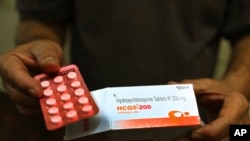 Seorang apoteker menunjukkan tablet hidroksiklorokuin di New Delhi, India, 9 April 2020. Presiden Donald Trump mengatakan dia mengonsumsi obat malaria itu untuk melindungi diri dari penularan virus corona (Covid-19).