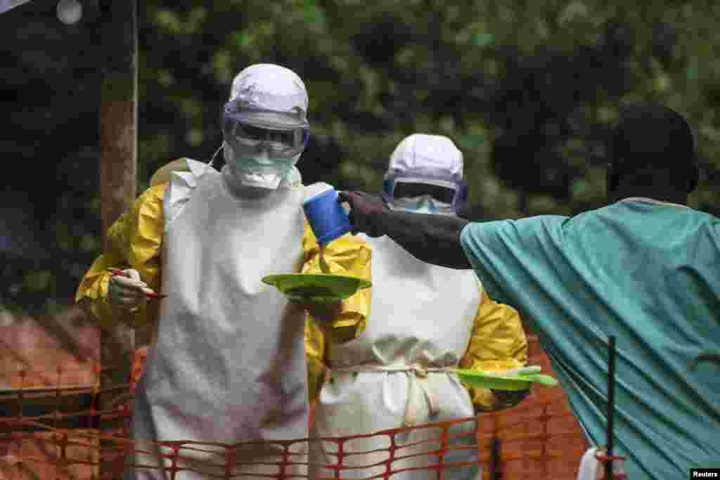 Medical staff working with Medecins Sans Frontieres (MSF) prepare to bring food to patients kept in an isolation area at the MSF Ebola treatment center, in Kailahun, July 20, 2014.&nbsp;