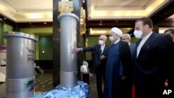 FILE - In this April 10, 2021, photo released by the official website of the office of the Iranian presidency, Iranian President Hassan Rouhani, second from right, listens to the head of the Atomic Energy Organization of Iran Ali Akbar Salehi.