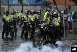 Police ride in to clear a protest in Caracas, Venezuela, June 28, 2017.